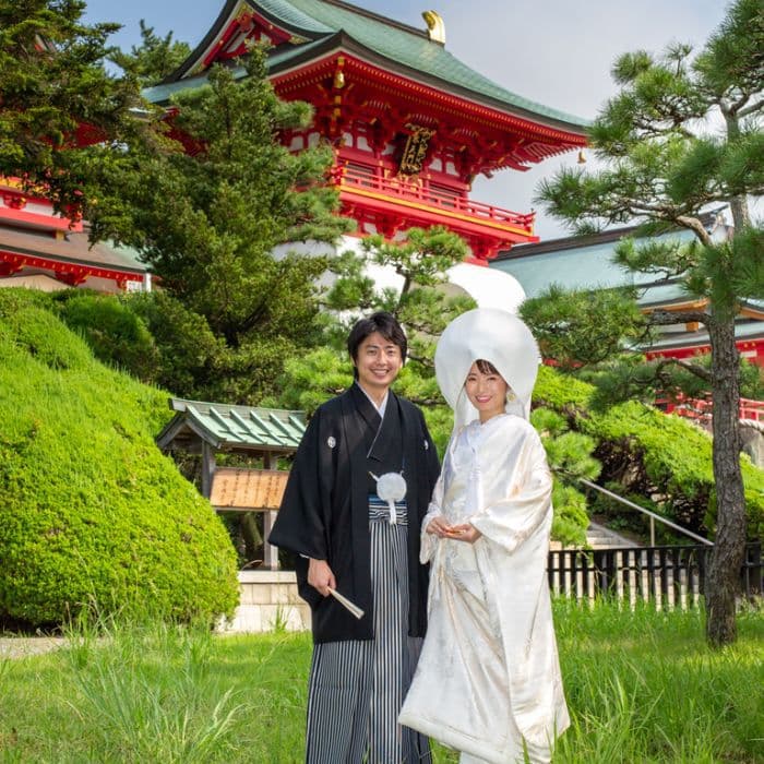 結婚写真神社の前で白無垢を着た女性と羽織袴の男性新郎新婦