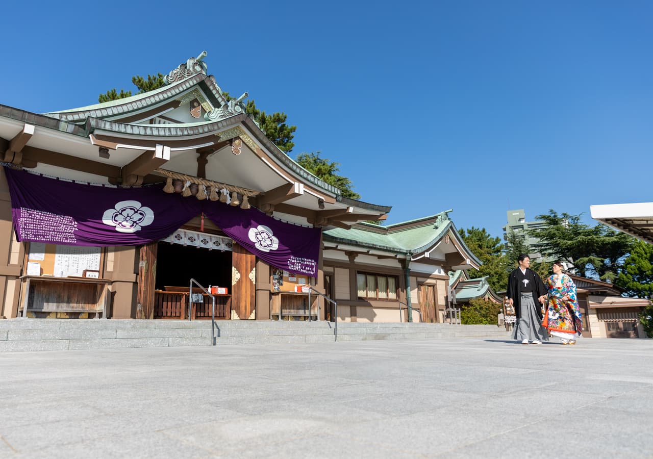 結婚写真神社を散歩する白無垢を着た女性と羽織袴の男性新郎新婦