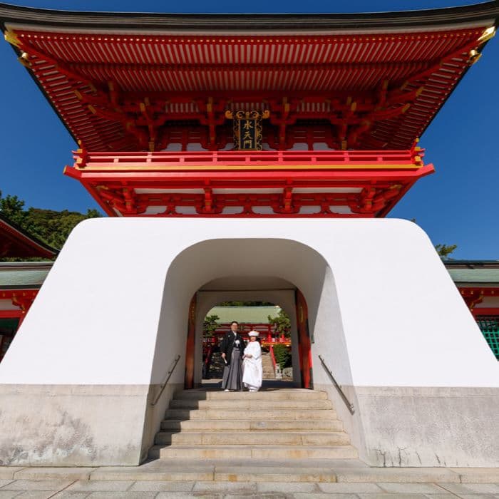 結婚写真神社の門で白無垢を着た女性と羽織袴の男性新郎新婦