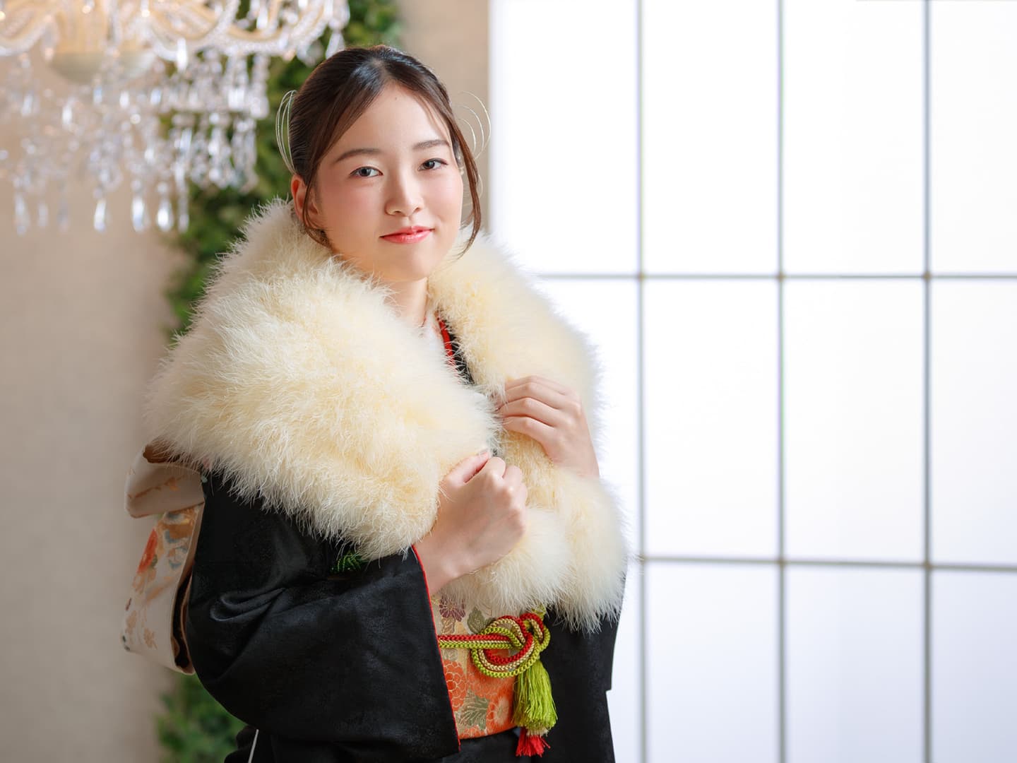 黒色の振袖を着た二十歳の女性が微笑んでいる写真